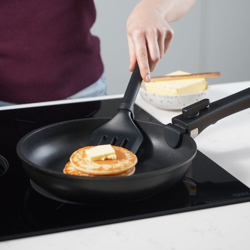 CuliStack koekenpan met afneembare handgreep op inductiekookplaat met verse pannenkoeken en een klontje boter